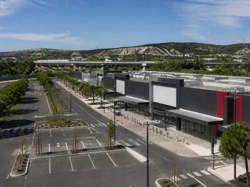 Galerie commerciale et parking d’une zone d’activité le long d’une autoroute