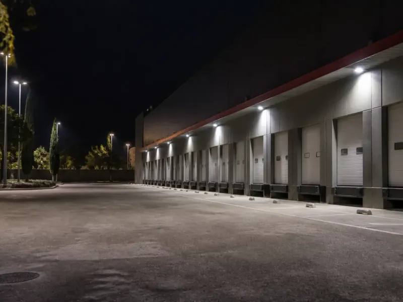 Cour d’entrepôt éclairée la nuit par des projecteurs LED au-dessus des quais
