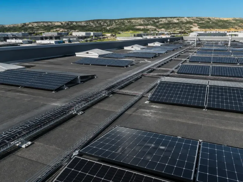 Rangées de panneaux solaires sur la toiture plate d’un entrepôt de zone d’activité